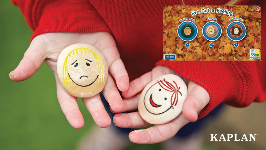 A small child holds two emotions stones in their hands, one with a happy face and the other with a sad face. A computer screen depicts the “I’ve Got Feeling” game in an insert on the upper right corner. 