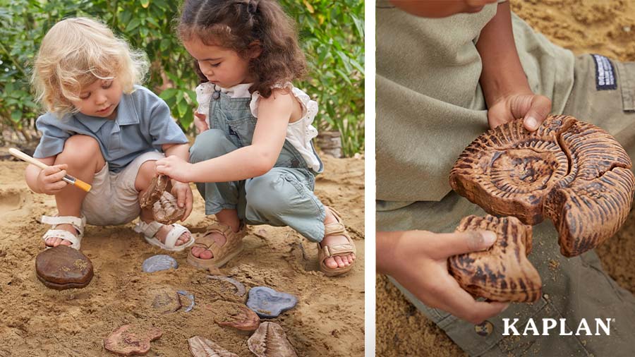 An image of two children playing with the Magnetic Matching Fossils Set while sitting in the sand on an early childhood playground. 