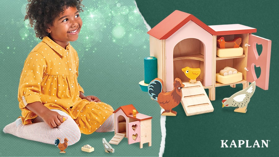 A child in a yellow dress sits on the floor while playing with the Wooden Chicken Coop Playset.