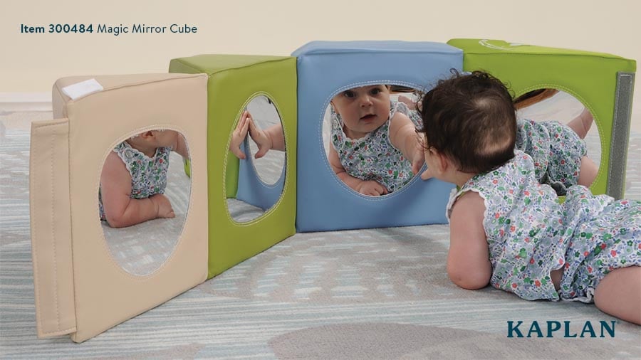 A young infant views her reflection in the Magic Mirror Cube during tummy time play. 