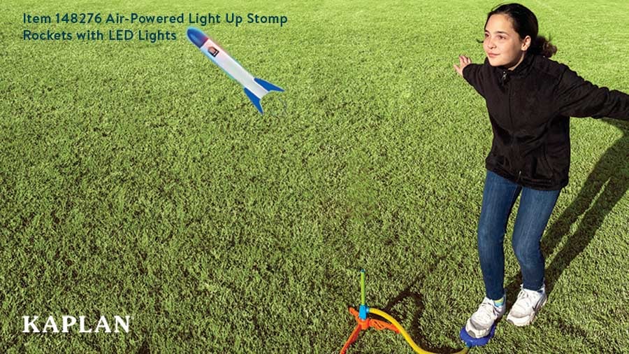 A girl in a black sweatshirt is outside, she is stomping on the launcher of the Air-Powered Light Up Stomp Rocket.
