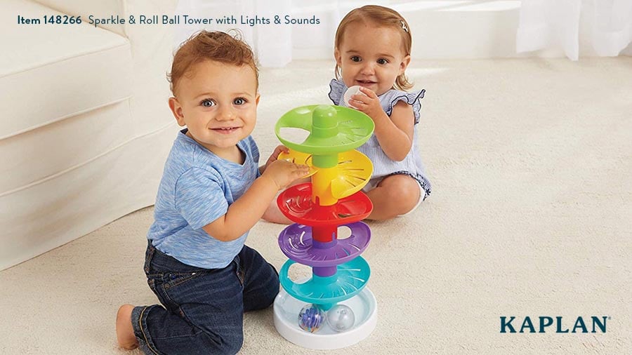 Two infants play with the Kaplan Sparkle & Roll Ball Tower.