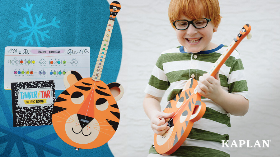 A young child smiles as he holds and strums the TinkerTar Tiger Guitar. 