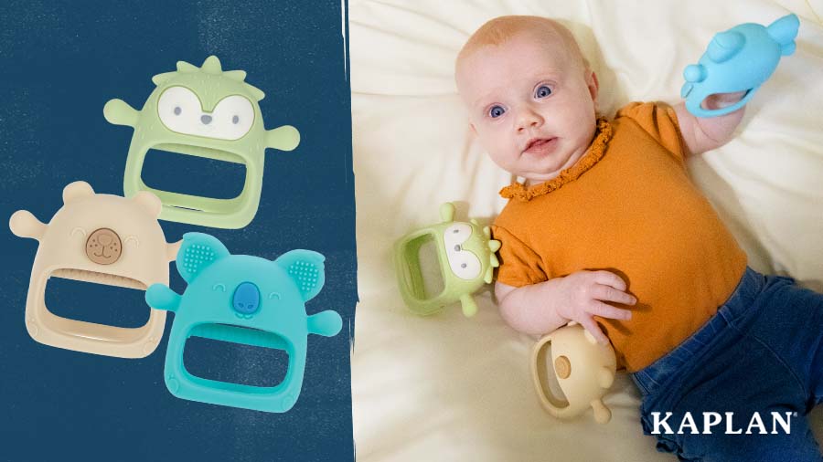 A young infant in an orange shirt is laying on a tummy time mat, the child is holding a blue Silicone Teething Mitt in their left hand. Two additional mitts are resting beside the infant on the floor. 