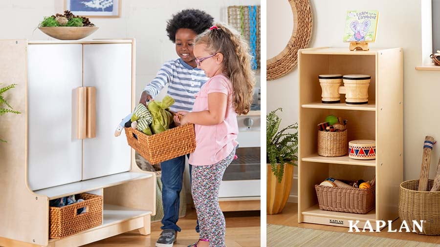 An image of Kaplan Early Learning's classroom storage units and two children moving a wicker basket full of dolls from a low shelf. 