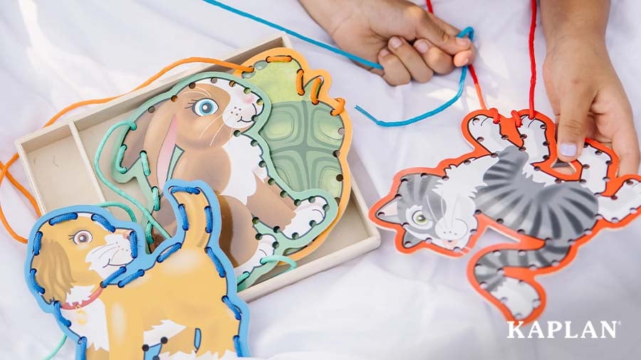 Child threading string through an animal-shaped lacing board