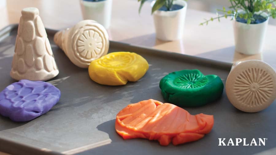 Multicolored playdough shapes drying on a baking sheet