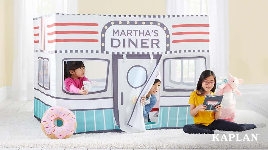 Three children playing restaurant in pretend diner