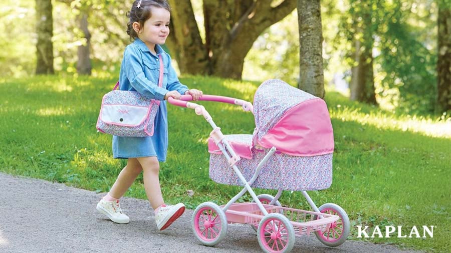 Child pushing play stroller while walking outside