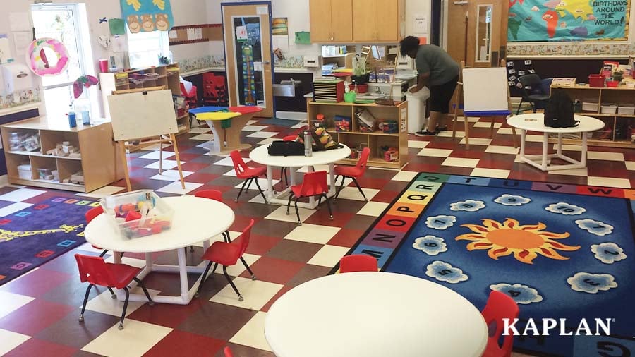 An early childhood educator places items on a shelf of a classroom.