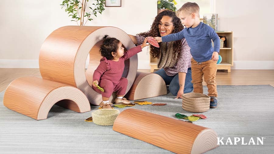 Toddlers and early childhood educator playing with log-themed climbing blocks