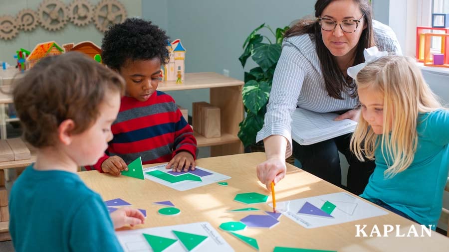 Early childhood educator providing guidance to children during a math lesson