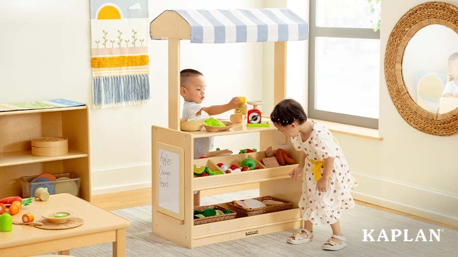 Two children playing farmer's market in the classroom's dramatic play center
