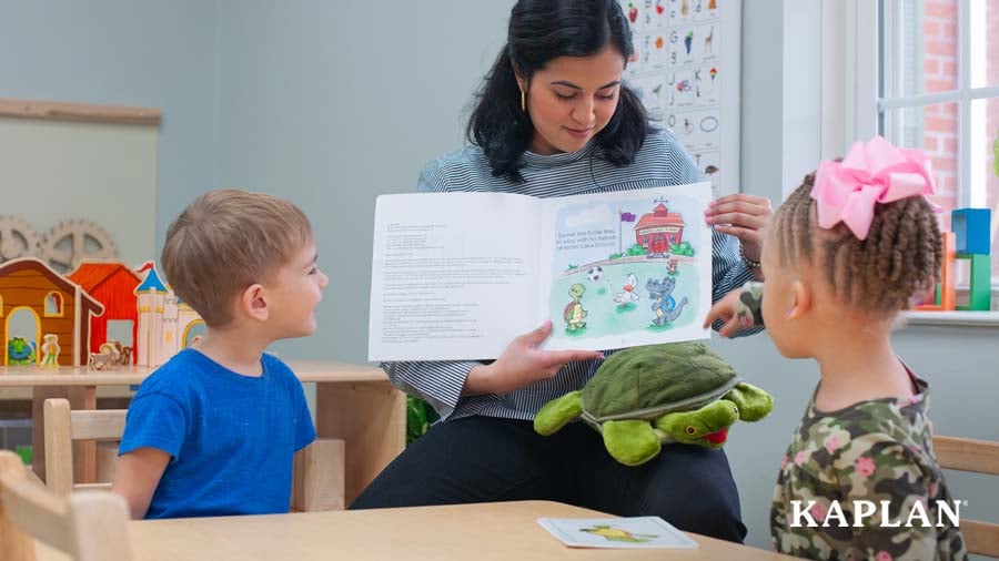 Early childhood educator reading book aloud to two children