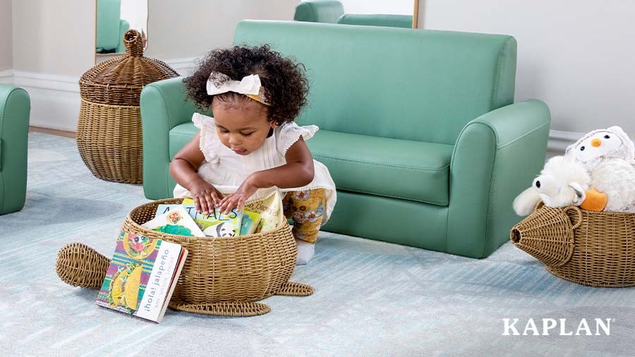 Toddler exploring books in a turtle-shaped wicker basket