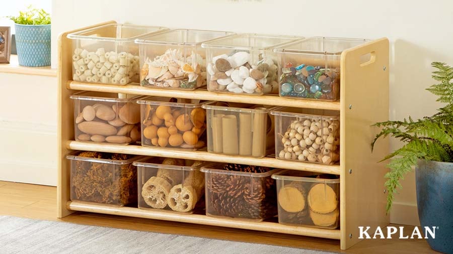 Low shelf with natural classroom materials organized in clear bins