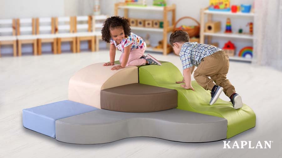 Two young children climbing a soft, multi-colored obstacle course