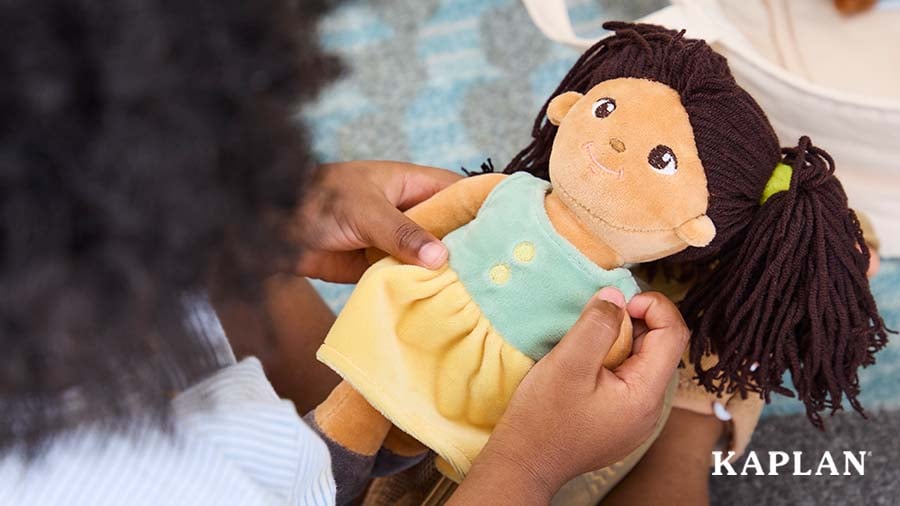 Toddler playing with a doll on the carpet