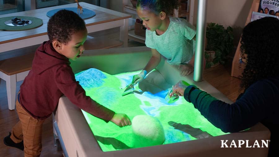 Two preschoolers enjoying sand play with the Illumination Station