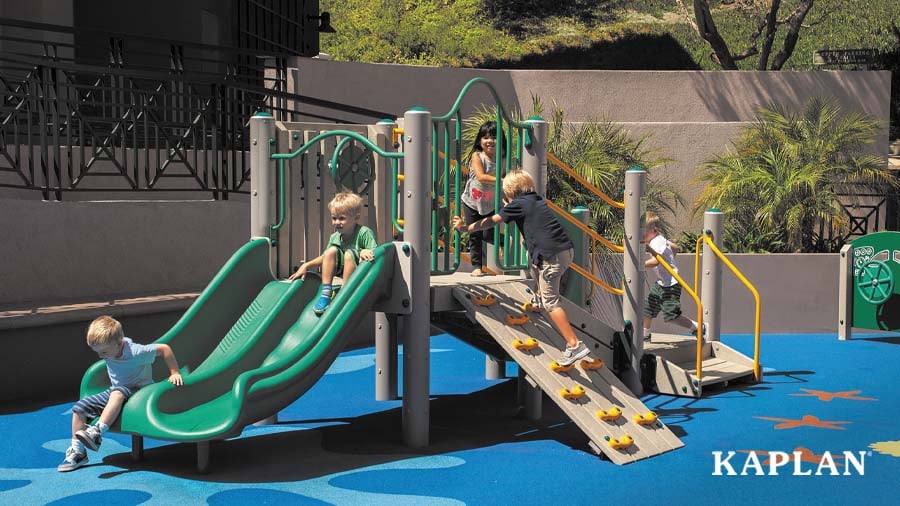 Five children playing on an outdoor playground set