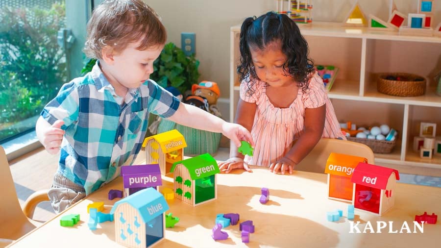 Two toddlers sorting colors at a table