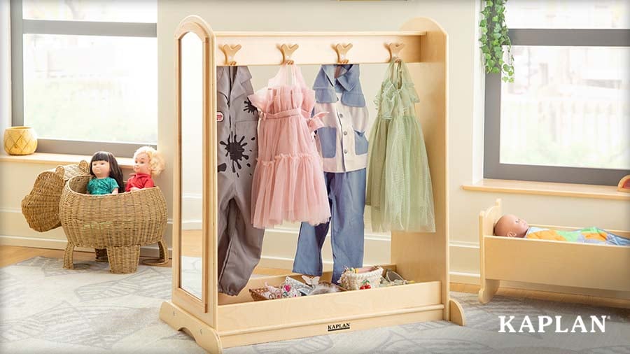 A wooden dress-up rack with a full-length mirror holds costumes and a tray of accessories