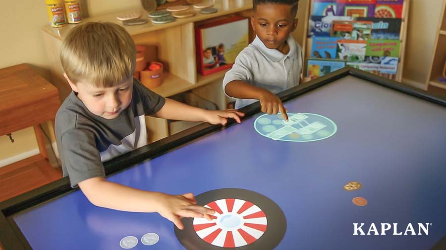 Two children are touching the display of an Inspire Interactive Panel while playing a Math Bubble game. 