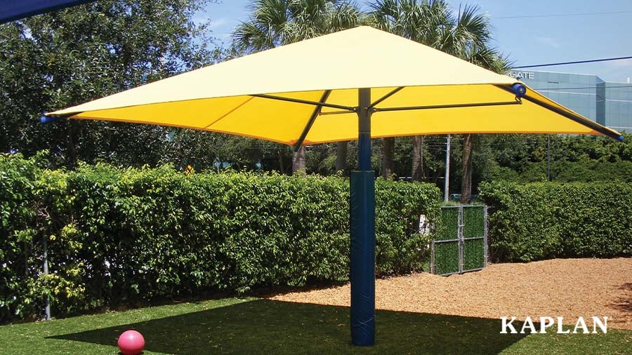 A yellow sun shade covers a portion of an outdoor recreation area. 