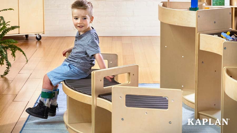 A young boy with braces on both feet sits on the inclusive Carolina Connections Rhythm Seating bench. 