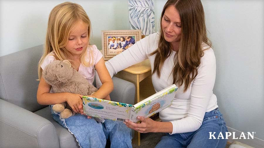 A caregiver and young child read the Warmies® Capybara and Board Book together