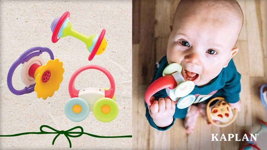 Three Whistle, Shake, and Roll Rattles beside an infant chewing on the car-shaped rattle