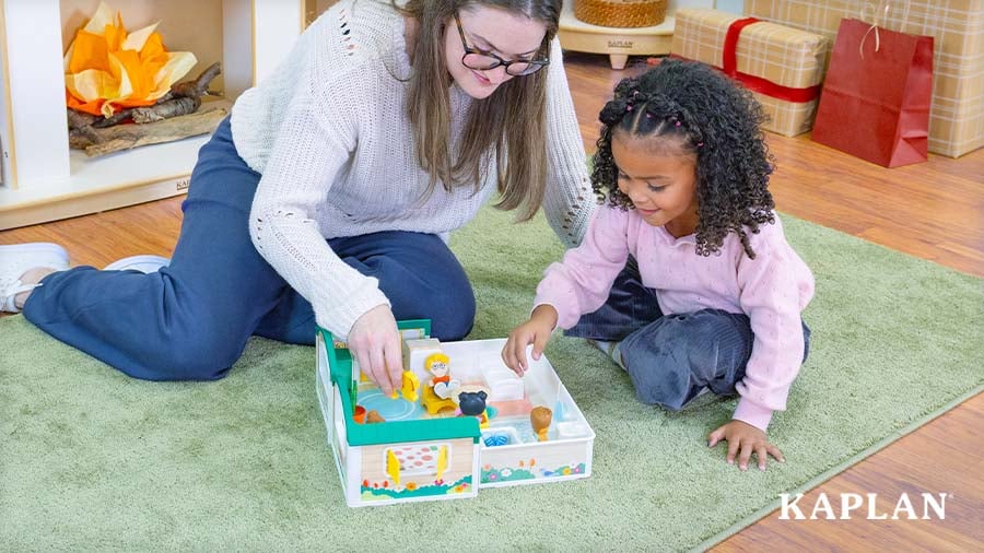Young child playing with the Cheery Lane House Playset alongside an early childhood educator