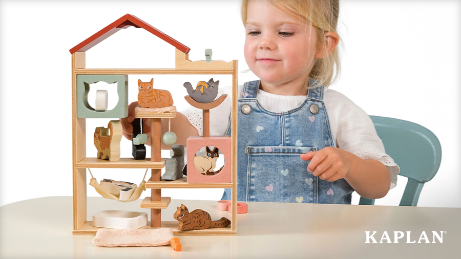 A smiling preschooler playing with a cat in the Purrfect Stay Cat Hotel