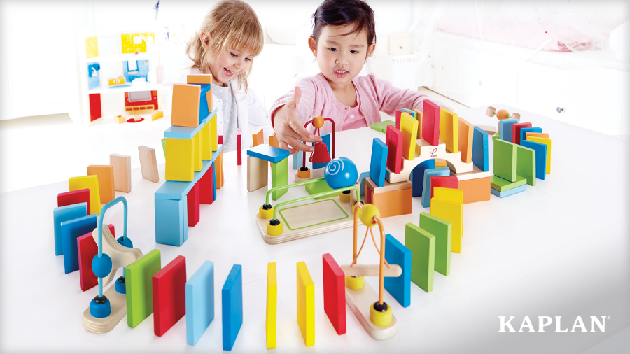 Two young children build an exciting domino path using Dynamo Dominoes Construction Set