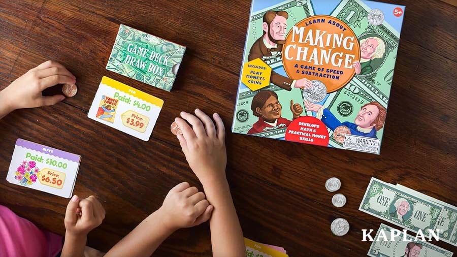 View of children’s hands playing the Making Change money game with play coins, bills, and price cards