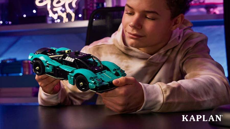 Child holding a teal blue LEGO Technic Aston Martin Valkyrie model car