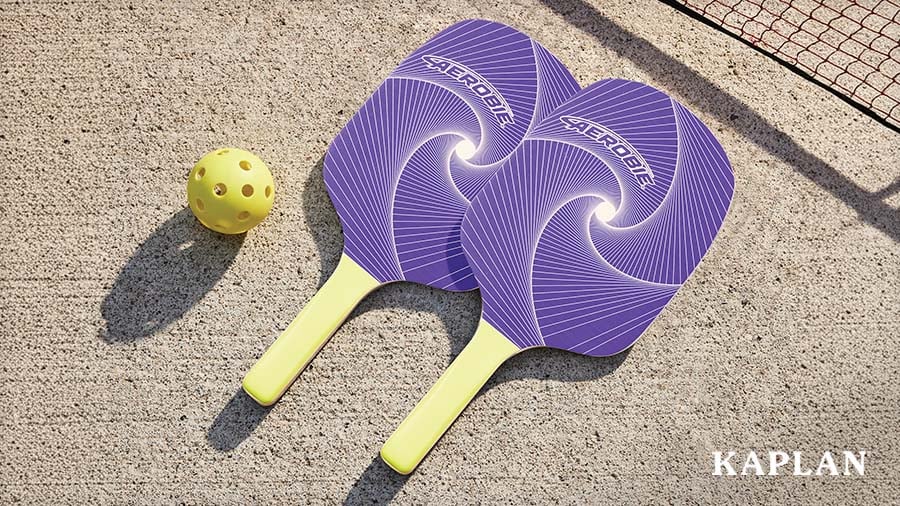Two purple pickleball paddles and a yellow ball on a concrete court