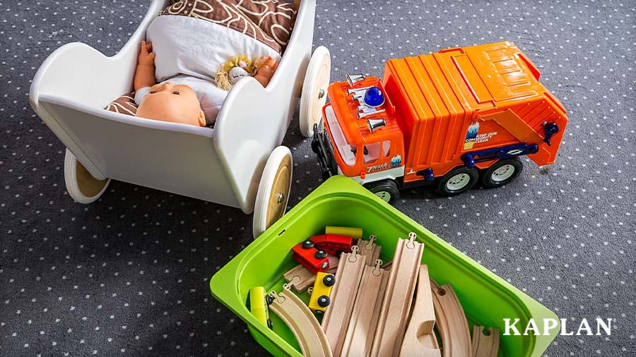 Dramatic play toys featuring a doll stroller, garbage truck, and wooden train tracks