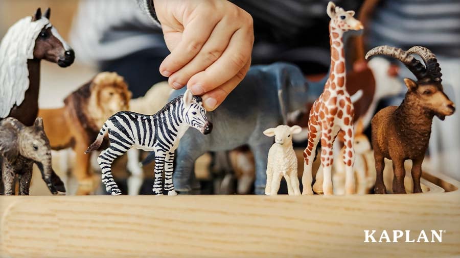 Young child playing with wildlife animal figures