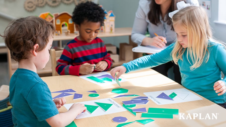 Three children sit at a table while placing green and blue shapes to match shapes printed on a sheet of paper.