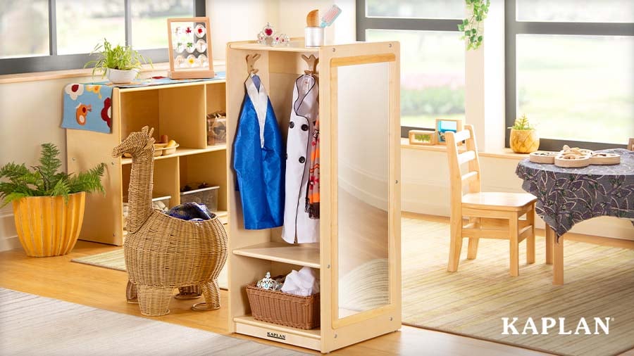 Dramatic play center featuring child-size shelves, cubbies, tables, and chairs