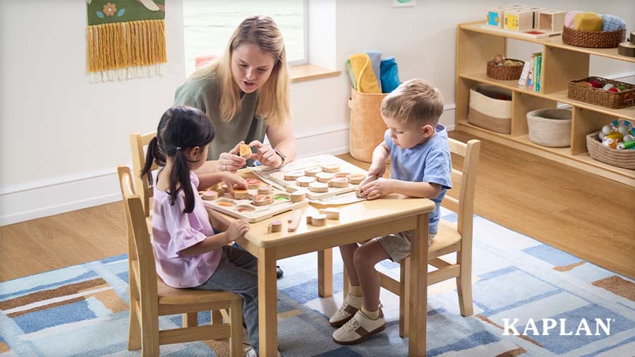 Early childhood educator helping two young children solve wooden puzzle sets