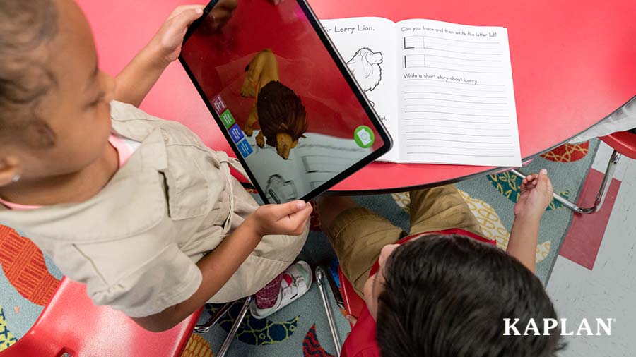 A young child is holding a tablet, a 3D lion is displaying on the screen as a feature of the Alive Studios mobile app for the Alive Student Journals. 