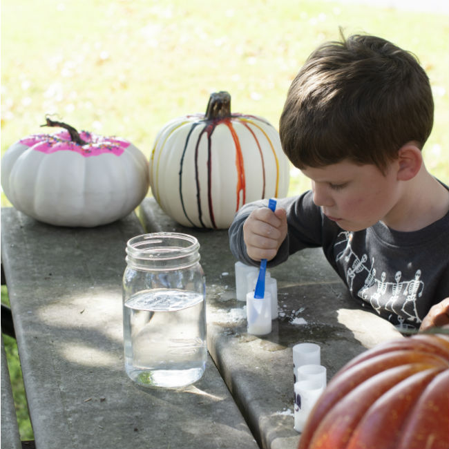 A little boy mixes water and cornstarch together