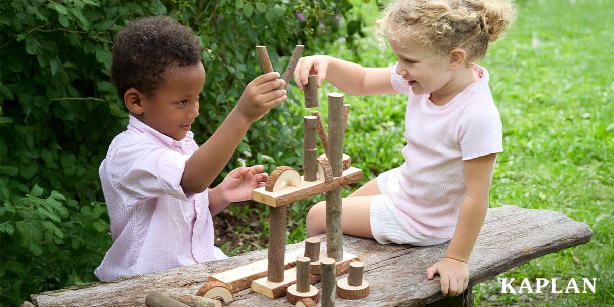 Featured image: Two children building wooden structures in an outdoor learning space - Read full post: Benefits of Play-Based Learning in the Elementary Classroom