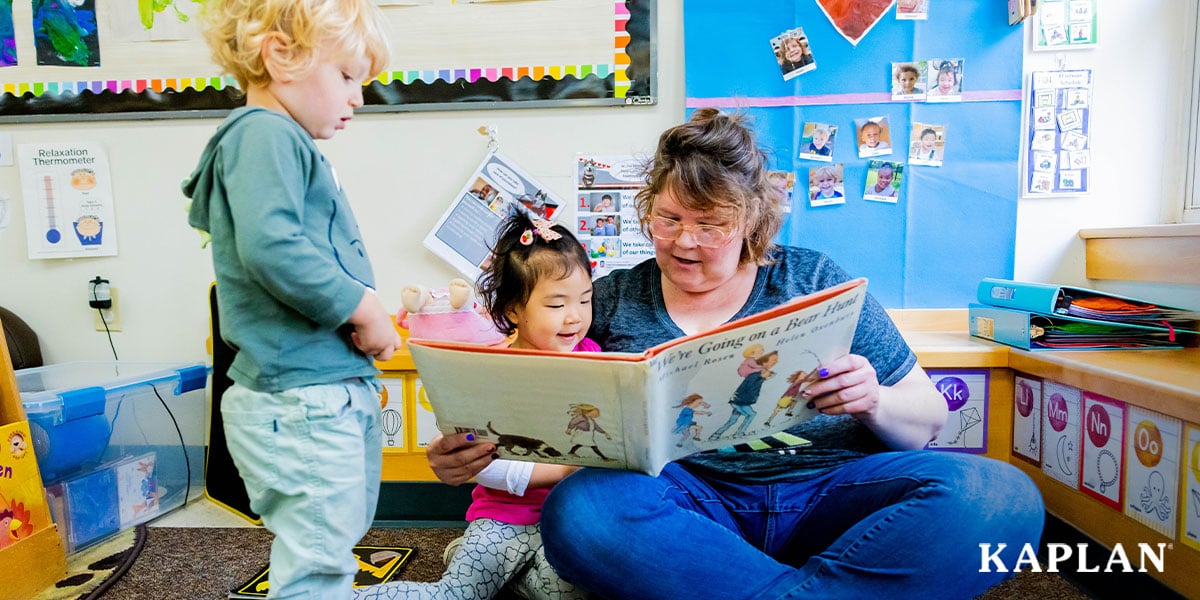 Featured image: An early childhood teacher sits on the floor of a classroom, holding a book open in front of her while looking down at the pages. One young child is sitting on the teacher's lap, looking down at the book, while a second child is standing beside the teacher, also looking down at the book. e - Read full post: Getting Started With the Ohio Early Care and Education Access Grants