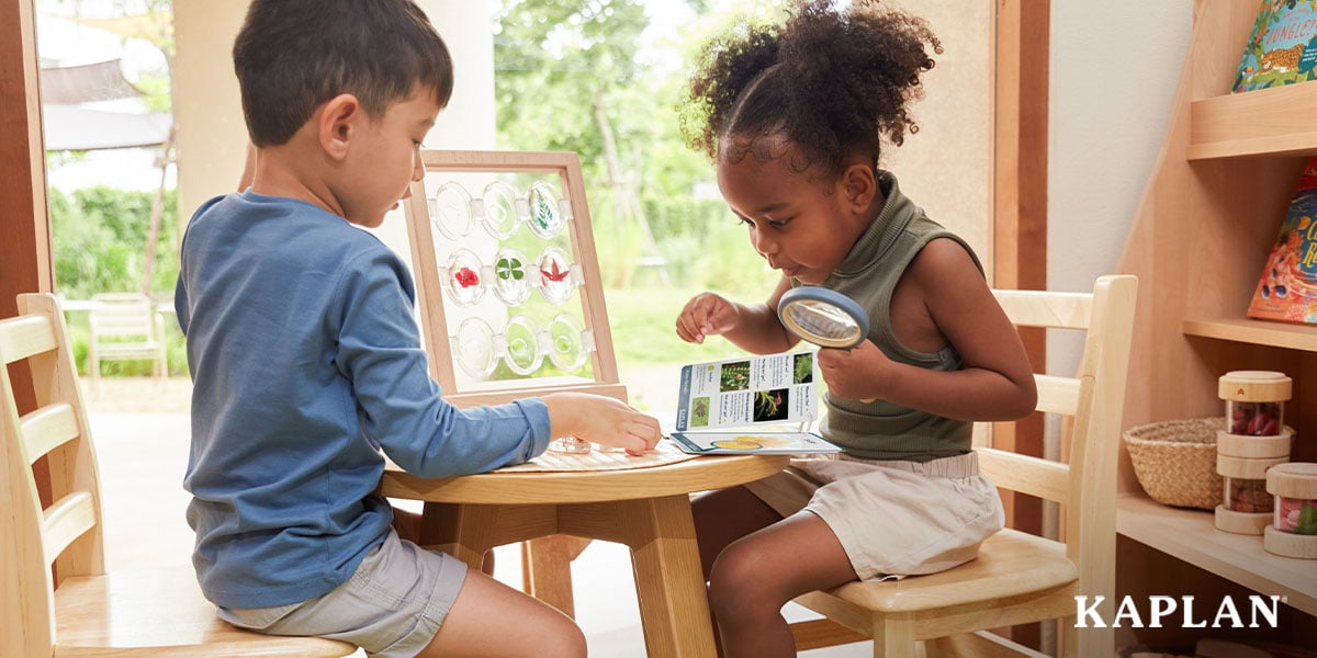 Featured image: A preschool-aged boy and a preschool-aged girl sit at a small round table and examine acrylic stones with small leaves set inside them - Read full post: How Much Does It Cost to Furnish a Head Start Classroom?