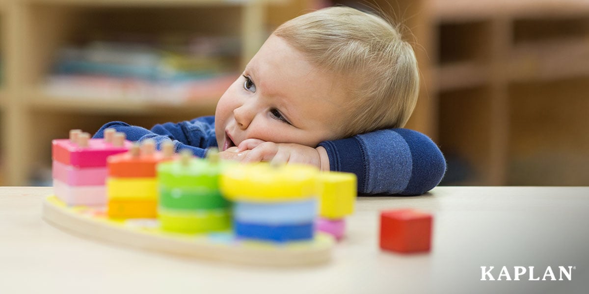 Featured image: Toddler resting their head on a classroom table alongside a colorful stacking toy - Read full post: The Surprising Reasons Children Stop Engaging With Classroom Materials